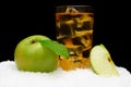 Frozen apple juice,ice cubes and apple with leaves on black on snow Royalty Free Stock Photo