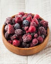 Frozen assorted berries in a wooden bowl on a white background. Berries, frozen foods. Royalty Free Stock Photo