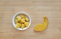 Frozen baby food homemade, Yellow heart from pumpkin Cubes in bowl and tray on wooden board