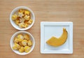 Frozen baby food homemade, Yellow heart and star from pumpkin Cubes in ceramic bowl on wooden board