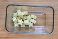 Frozen baby food homemade, Yellow star from lettuce Cubes in square glass bowl on wooden board