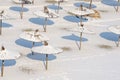 Frozen beach. Snow on the sand and parasol