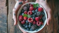 frozen berries, black currant, red currant, raspberry, blueberry. top view in a vintage ceramic white bowl on rustic wooden table Royalty Free Stock Photo