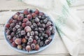 Frozen berries fruits background in ceramic plate close up.Fruits with frost. on vintage white wooden planks, blank space for text Royalty Free Stock Photo