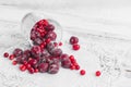 Frozen berries in a glass cup on the light wooden background. Cherry and cranberry