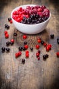 Frozen berries in plate on wooden background Royalty Free Stock Photo