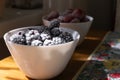 Frozen berries in white bowls on a wooden table.