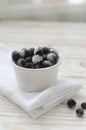 Frozen black current in white bowl on minimal background Royalty Free Stock Photo