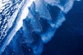 Frozen blue water surface and wave covered with ice, snow abstract winter background wallpaper Royalty Free Stock Photo