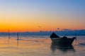 frozen boat in winter on the lake at sunrise