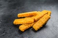 Frozen bread crumbed fish fingers. Black background. Top view Royalty Free Stock Photo
