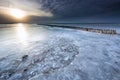 Frozen breakwater on big lake in winter