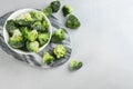 Frozen broccoli florets on light grey table. Vegetable preservation