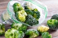 Frozen broccoli in a plastic bag on wooden table. Selective focus Royalty Free Stock Photo