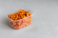 Frozen buckthorn in a plastic container - vitamins from the refrigerator all year round