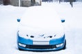Frozen car covered snow at winter day, view front window windshield and hood on snowy background Royalty Free Stock Photo
