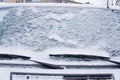 Frozen car windshield covered with ice and snow on a winter day. Close-up Royalty Free Stock Photo