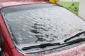 Frozen car windshield covered with ice and snow on a winter day. Royalty Free Stock Photo