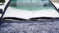 Frozen car windshield covered with ice and snow on a winter day. Close-up view Royalty Free Stock Photo
