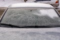 Frozen car windshield covered with ice and snow on a winter day. Close-up view Royalty Free Stock Photo