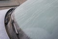 Frozen car windshield covered with ice and snow on a winter day. Close-up view. Close up of frozen windshield and car wiper in Royalty Free Stock Photo
