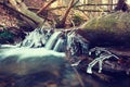 Frozen cascade of waterfall icy twigs and boulders in frozen foam