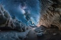 frozen cavern, with view of distant stars and galaxies, providing glimpse into the vastness of space