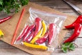 Frozen chili pepper on a wooden board on the table. Frozen vegetables. Frozen food