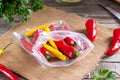 Frozen chili pepper on a wooden board on the table. Frozen vegetables. Frozen food