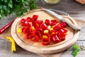 Frozen chili pepper on a wooden board on the table. Frozen vegetables. Frozen food
