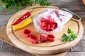 Frozen chili pepper on a wooden board on the table. Frozen vegetables. Frozen food