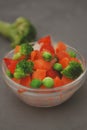 Frozen Colorful Vegan Healthy Vegetables. Brocolli, Carrots, Peas, Pepper. vertical Image. Gray Background. Royalty Free Stock Photo