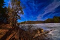 Frozen cox hollow lake and pine lined rock bluff on a sunny winter day Royalty Free Stock Photo