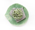 Frozen cut green beans in glass bowl on gray napkin on green wooden slice on white top view. Royalty Free Stock Photo
