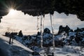 Frozen dripping water on the stone ceiling with bright sunlight in winter