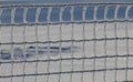 Frozen fence made of metal mesh covered with snowy hoarfrost, winter day. Winter snow texture. Close up Royalty Free Stock Photo