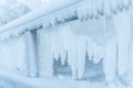 Frozen fence in winter. Huge icicles