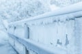 Frozen fence in winter. Huge icicles close up