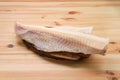 Frozen fillet of cod on wooden plate