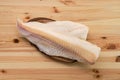 Frozen fillet of cod on wooden plate