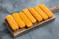 Frozen fish fingers, on wooden cutting board, on gray background Royalty Free Stock Photo