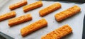 Frozen fish sticks are laid out on baking paper. Cooking a fish delicacy. Baking paper on a baking sheet. A quick lunch Royalty Free Stock Photo