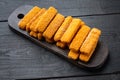 Frozen fish Sticks , on wooden cutting board, on black wooden table background Royalty Free Stock Photo