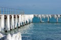 Frozen fishing pier with hanging icicles in a sunny winter day