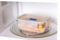 Frozen food in containers in the microwave, close up Royalty Free Stock Photo