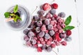 Frozen forest berries and cocktail in ice cubes on wooden table background. Royalty Free Stock Photo