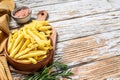 Frozen French fries in a bowl, organic vegetables. White wooden background. Top view. Copy space