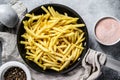 Frozen French fries in a frying pan. Gray background. Top view