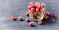 Frozen and fresh berries in a glass pial on a black background. Royalty Free Stock Photo