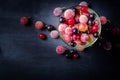 Frozen and fresh berries in a glass pial on a black background. Royalty Free Stock Photo